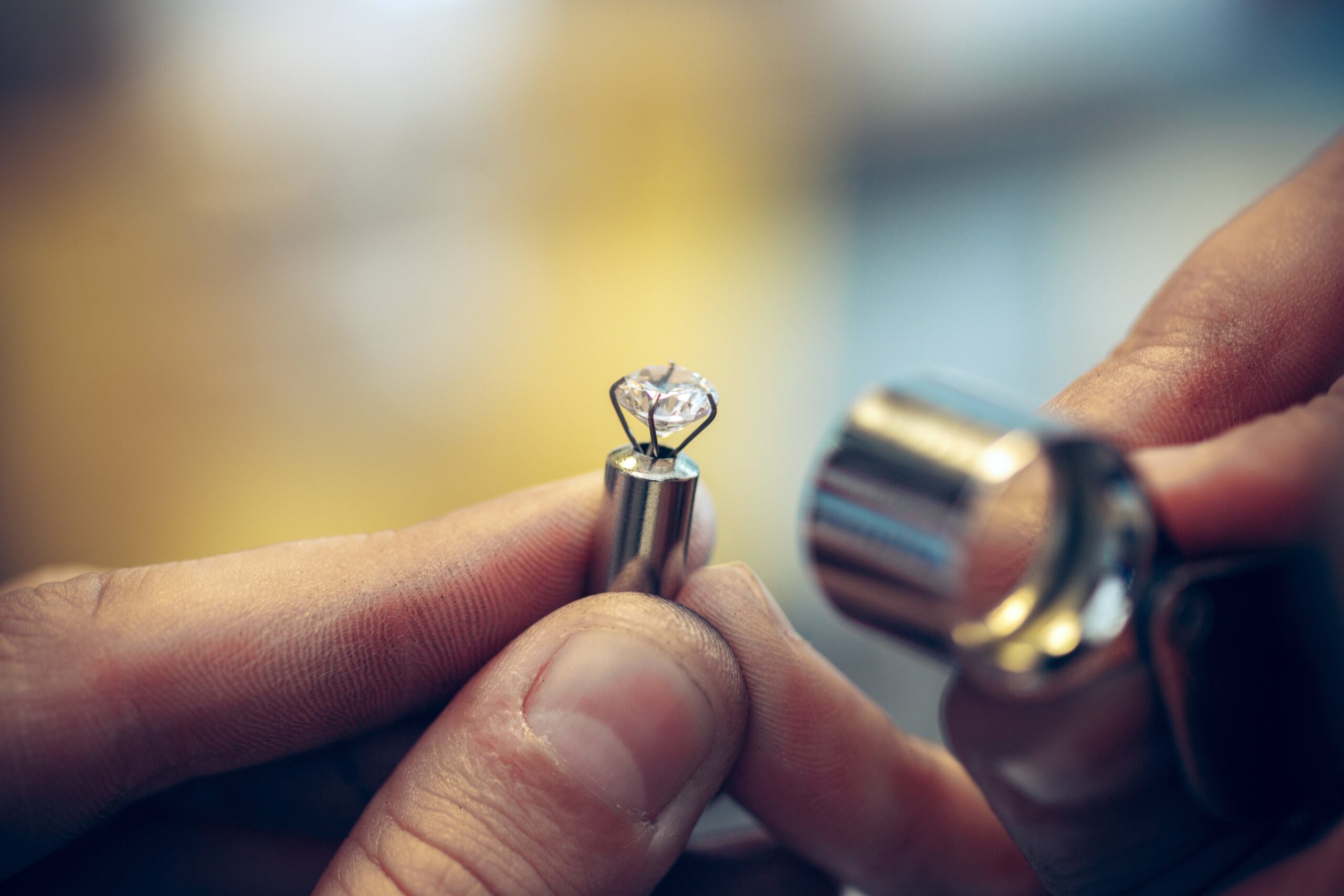 A jeweller inspecting a loose sapphire through a magnifying glass.